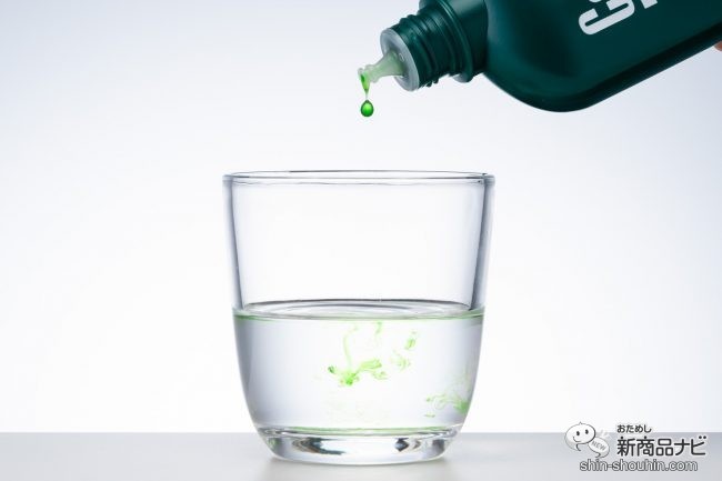 グラスに入れた水に液を滴下しているところ